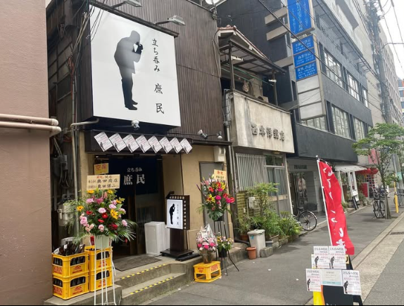花で彩られた立ち呑み庶民の店舗外観
