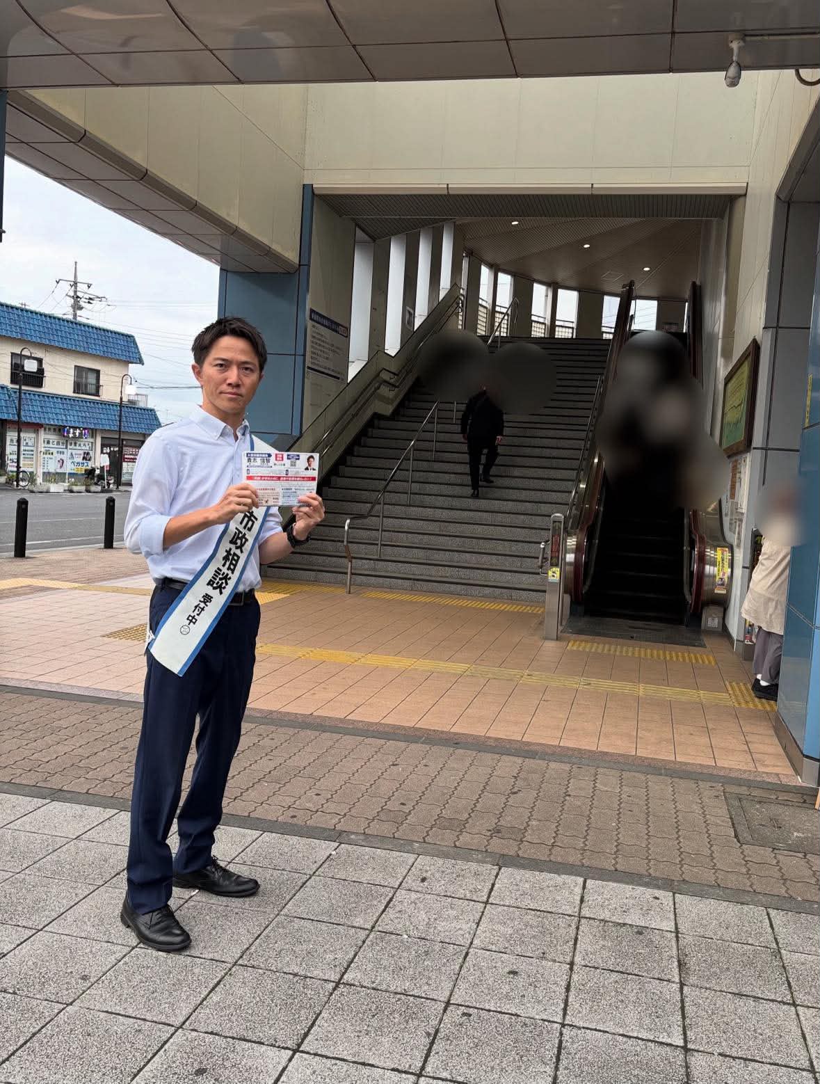 駅前に立ち、活動する貴志信智さん。