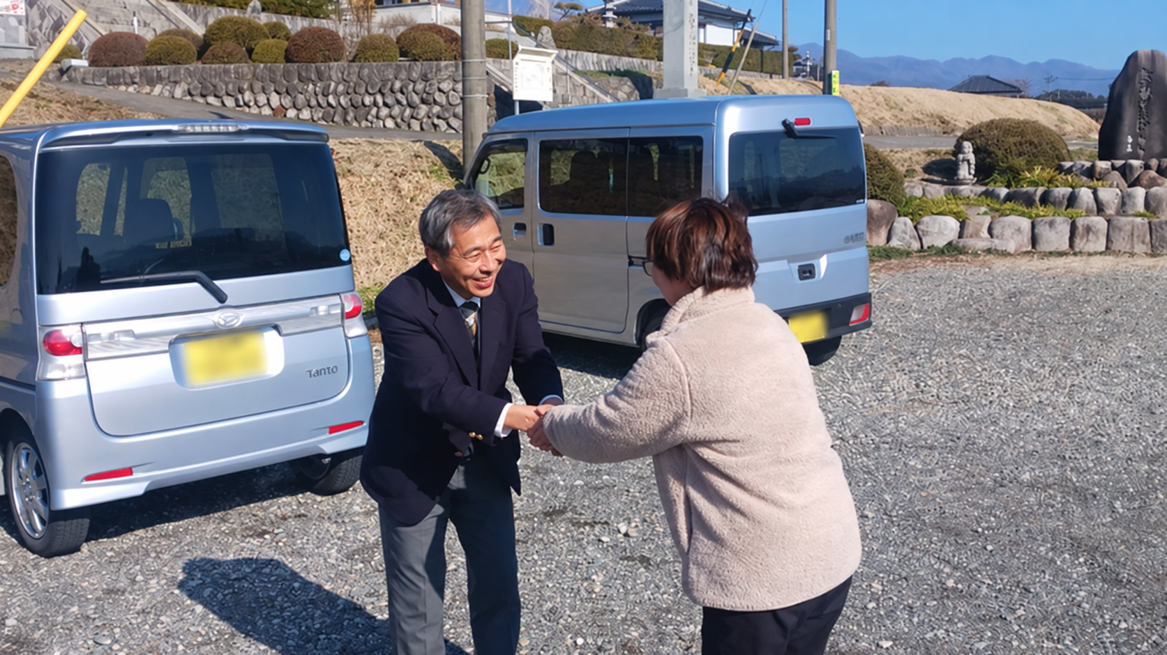 屋外で市民と握手する吉田浩之さん